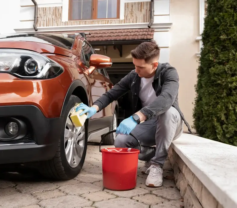Lavage auto à domicile Sainte-Marguerite-d'Elle : professionnel intervenant sur un véhicule
